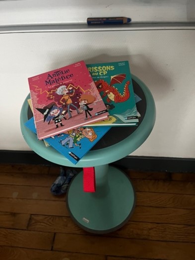 Petit tabouret avec plusieurs livres jeunesse dessus.